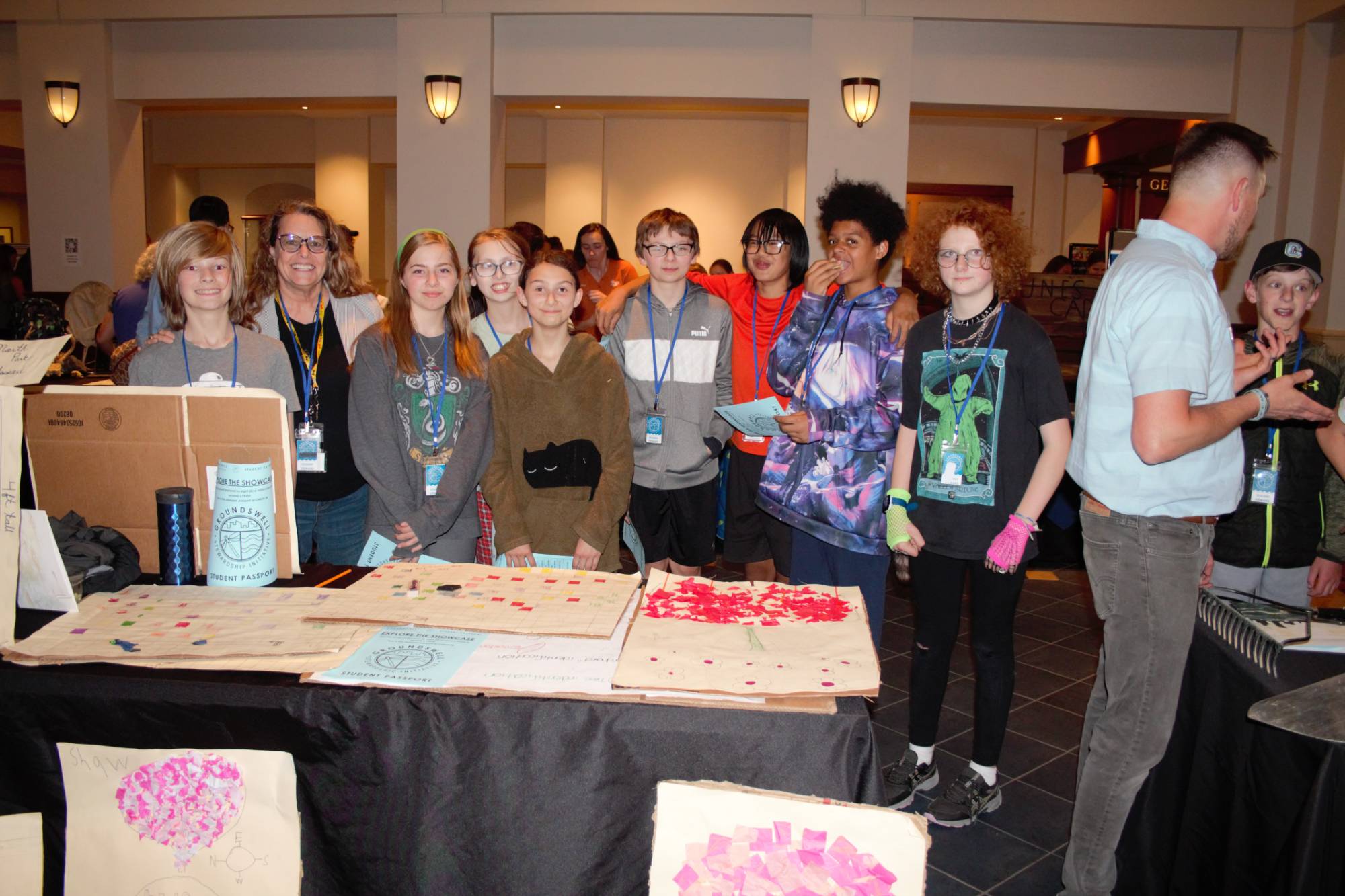 Showcase table exhibit photo with students standing by their trifold poster presentation